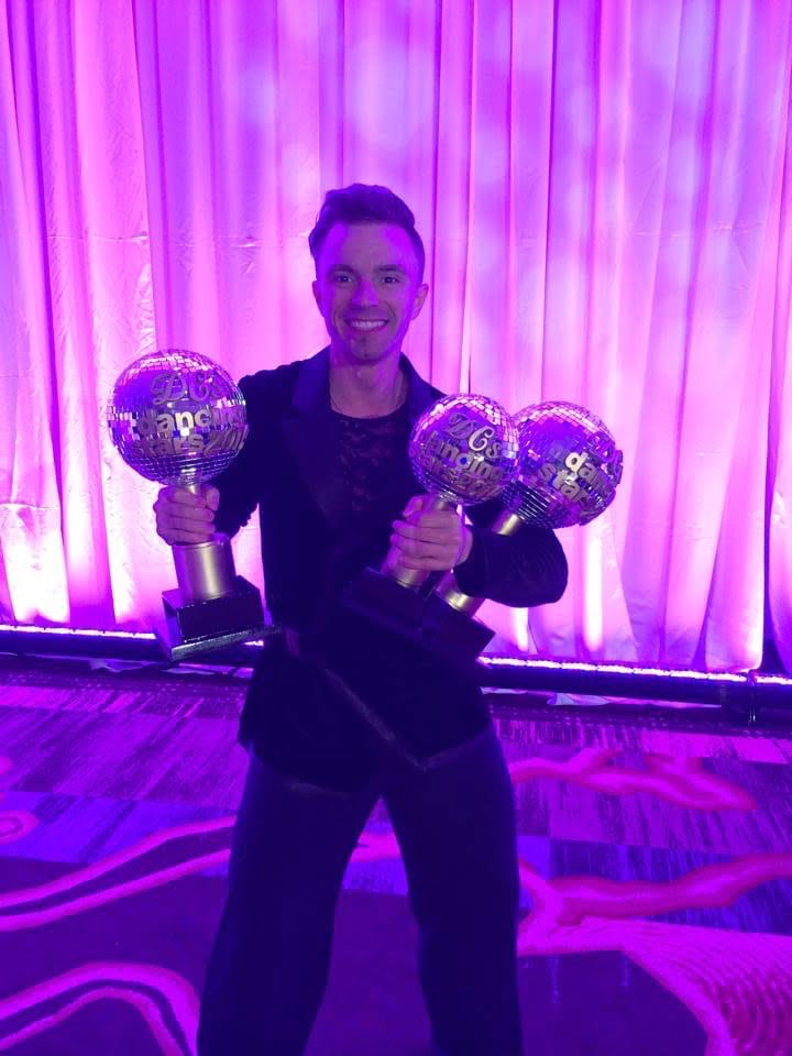 Sevrin Shapiachan holding championship trophies